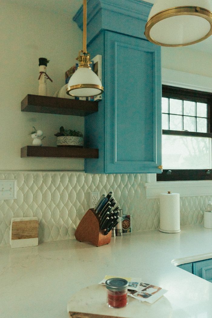 About Stylish kitchen design featuring blue cabinets and sleek countertops with natural light.